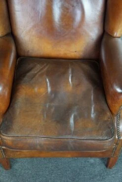 Very Rugged Wingback Armchair Made Of Cognac-colored Sheep Leather Finished With Decorative Nail Hea 13 Very Rugged Wingback Armchair Made Of Cognac-colored Sheep Leather Finished With Decorative Nail Hea -Chairly Shop 1746b5f1 9590 49e6 85e2 19ac1ed9a8a5
