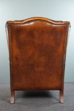 Very Rugged Wingback Armchair Made Of Cognac-colored Sheep Leather Finished With Decorative Nail Hea 17 Very Rugged Wingback Armchair Made Of Cognac-colored Sheep Leather Finished With Decorative Nail Hea -Chairly Shop 58cce9fa 0487 417c ab2a 350f13113482